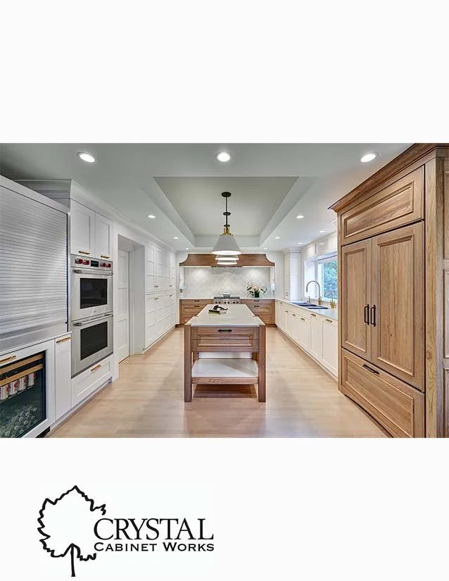 Bright, modern kitchen with white cabinets, wooden accents, and a large central island, featuring built-in stainless steel appliances and a window above the sink.