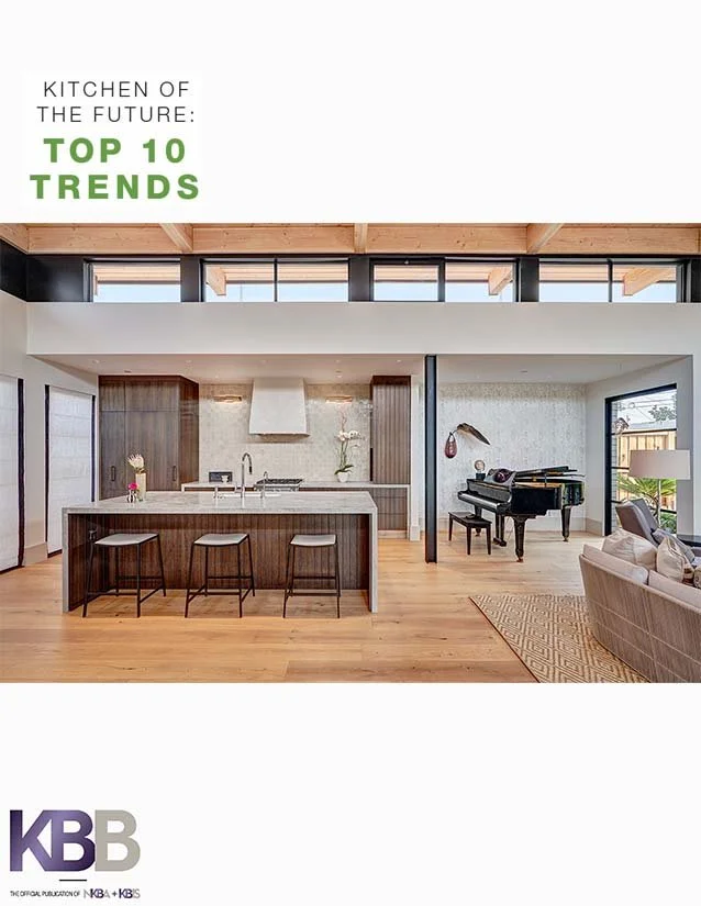 Modern open-concept kitchen with island, barstools, and a living area featuring a grand piano and a beige sofa.