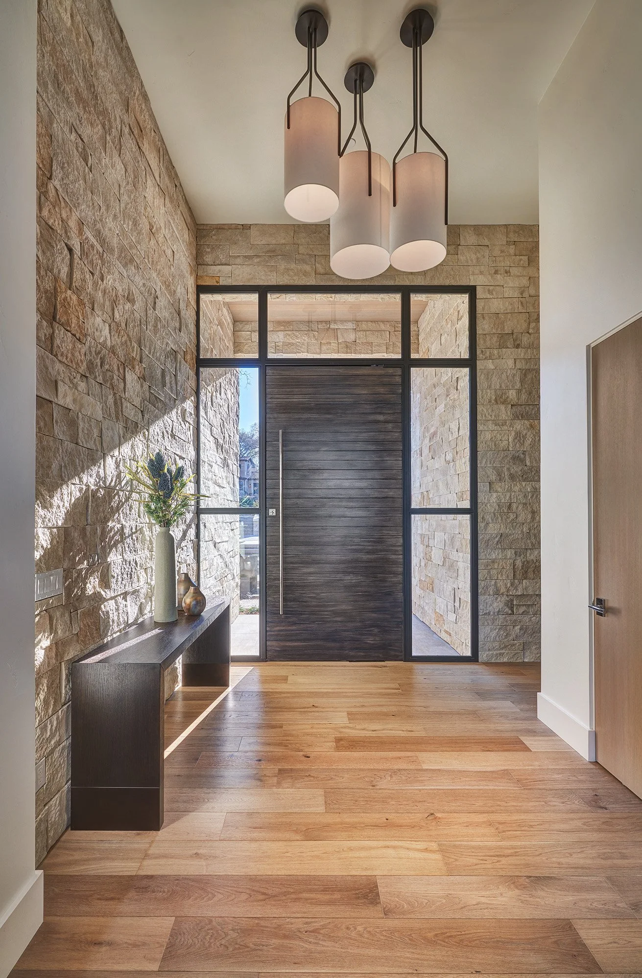 Modern new construction home, entry with large door and wrap around glass sidelites 