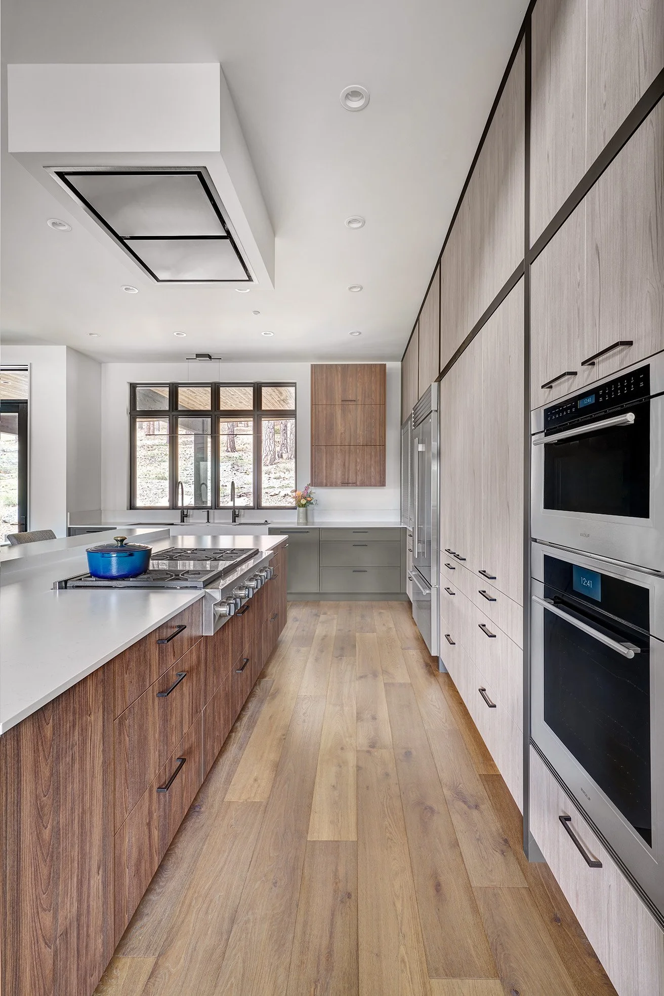 Mountain modern kitchen interior design, warm wood laminate cabinetry, earthy green cabinetry accents, large seating island, The Galley Workstation sink