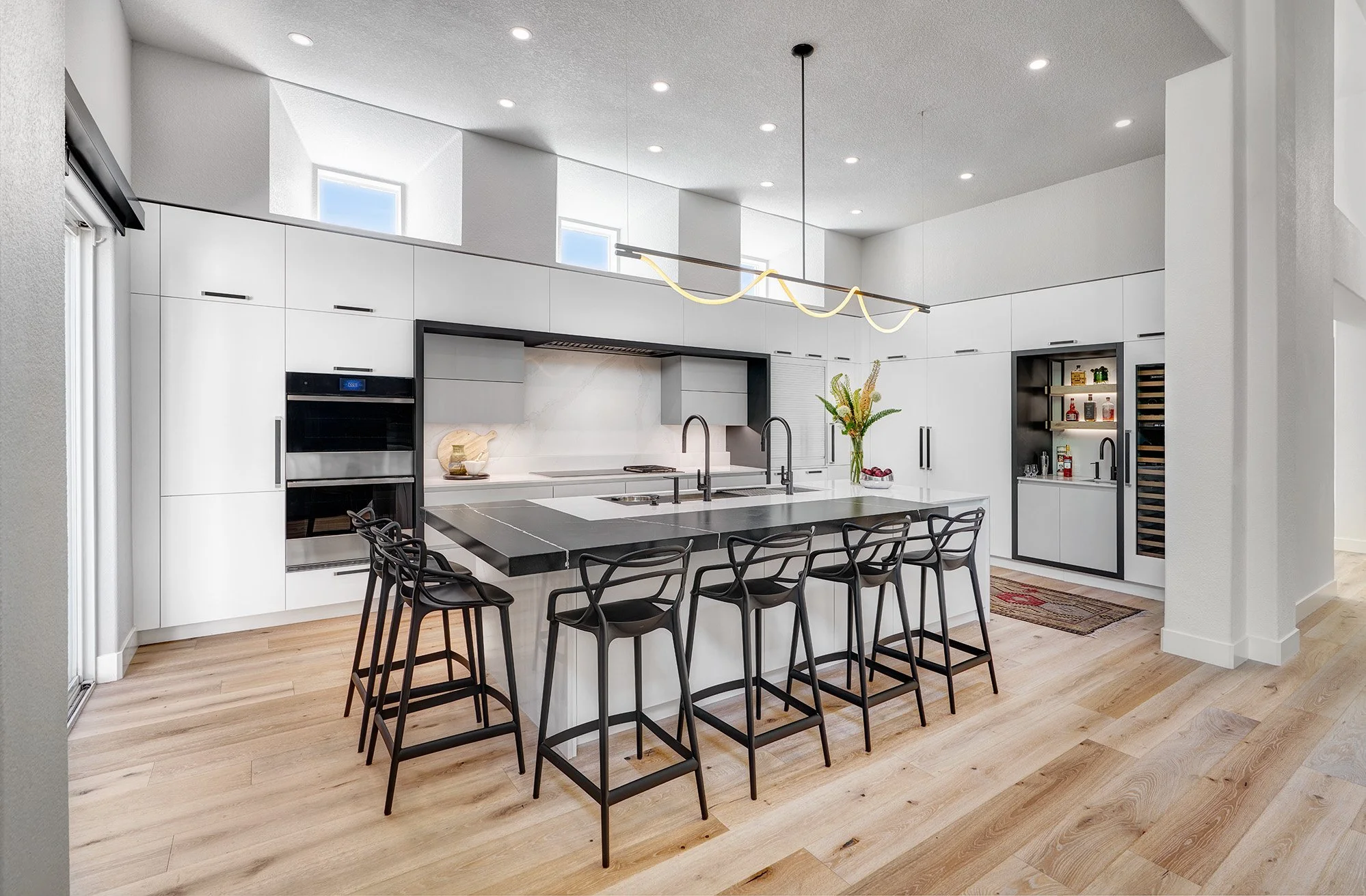 Modern kitchen remodel, black + white, large island, European cabinetry, Luke Lamp Co. chandelier