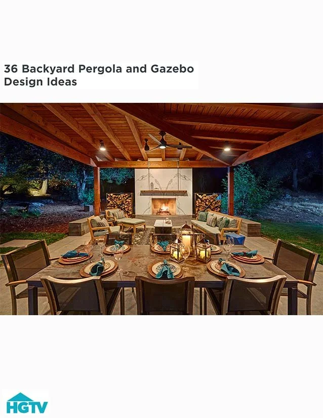 Outdoor backyard patio with a dining table set for eight, a seating area with chairs and cushions, a fireplace, and decorative lanterns, under a wooden pergola at night.