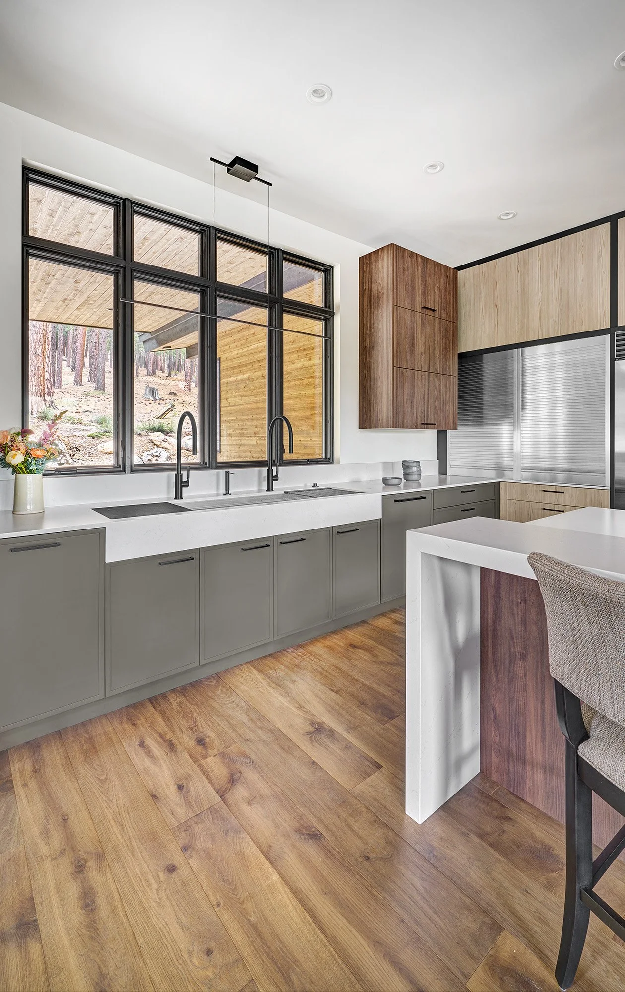 Mountain modern kitchen interior design, warm wood laminate cabinetry, earthy green cabinetry accents, large seating island, The Galley Workstation sink