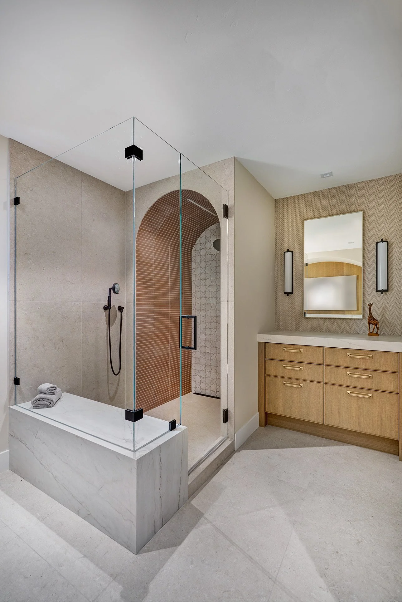 Large shower with arched alcove, warm contemporary makeup station cabinetry