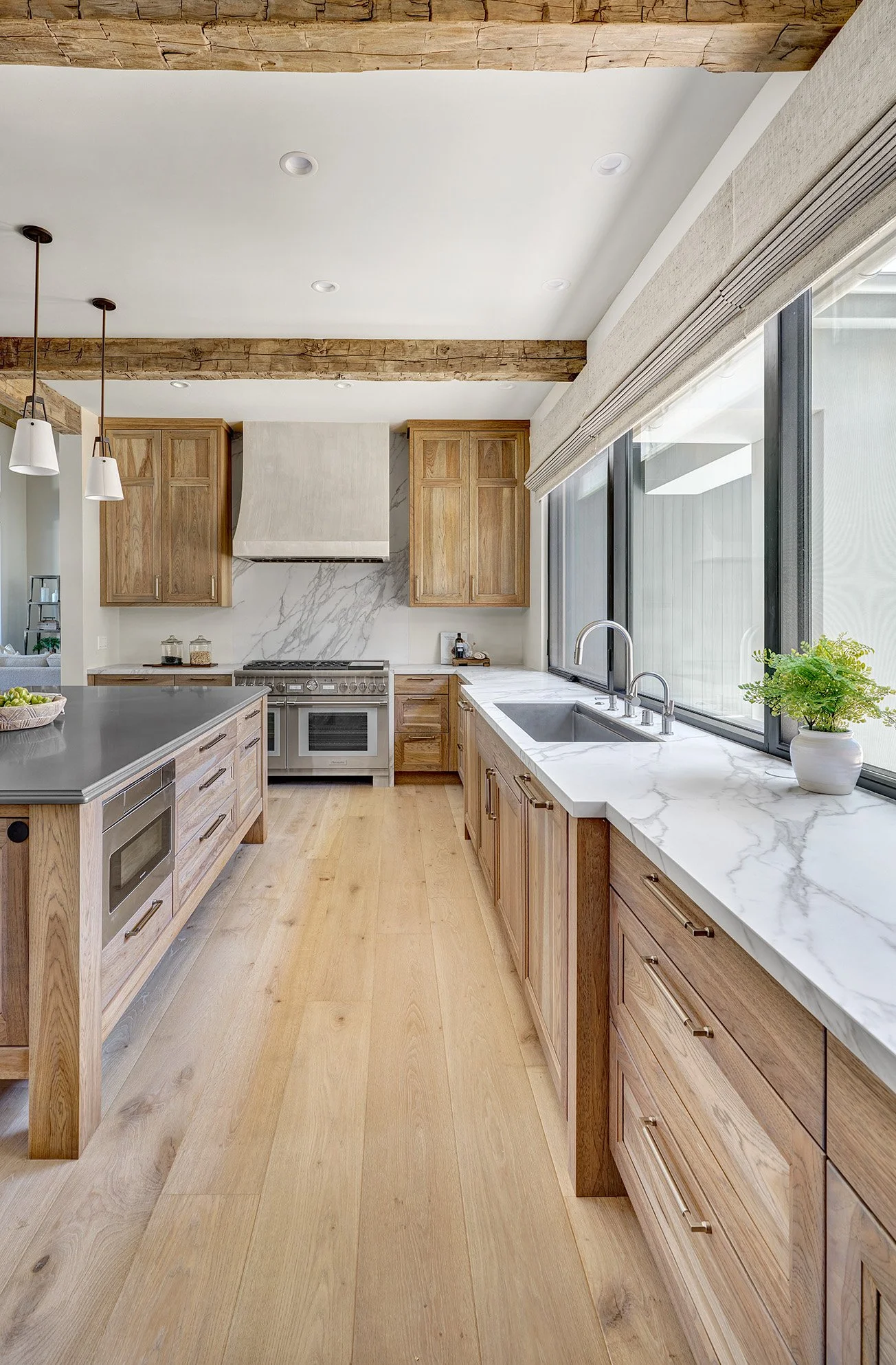 French Villa style hickory cabinetry, large metal finish island top, rustic beams, glass front cabinetry, Galley Workstation, Wolf Range