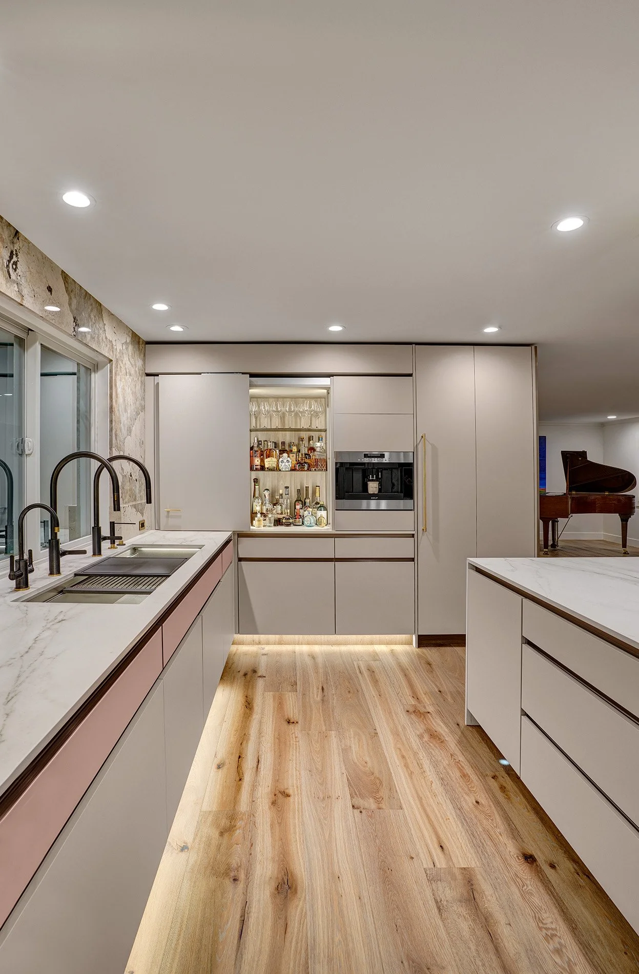 Modern kitchen remodel, blush glass drawer fronts, channel hardware, coplanar cabinet doors, bar