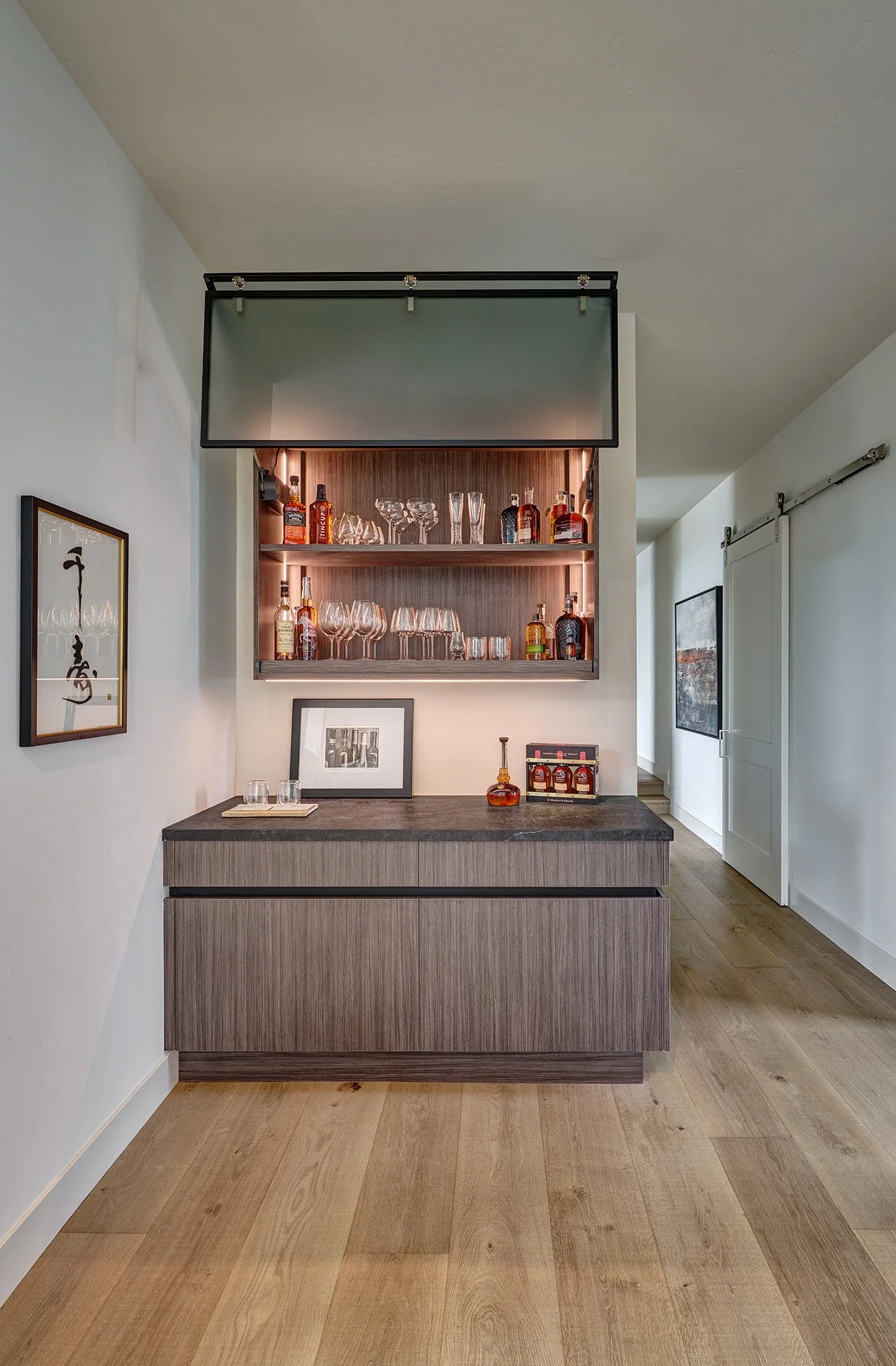 Modern new construction home, European laminate cabinetry, bar with channel hardware and glass fold up internally lit wall cabinet