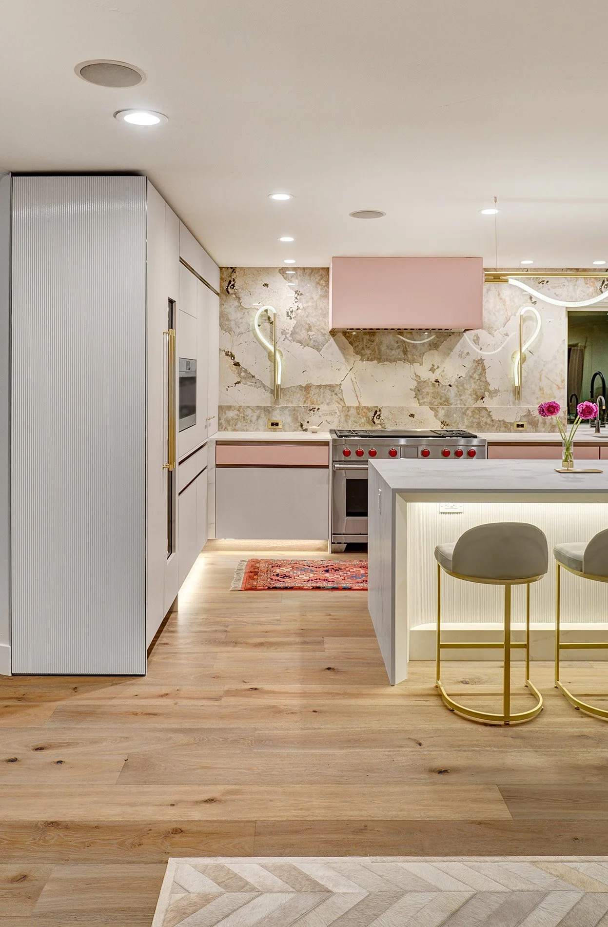 Modern kitchen remodel, blush glass drawer fronts and hood, custom ribbed paneling, European cabinetry, Wolf range