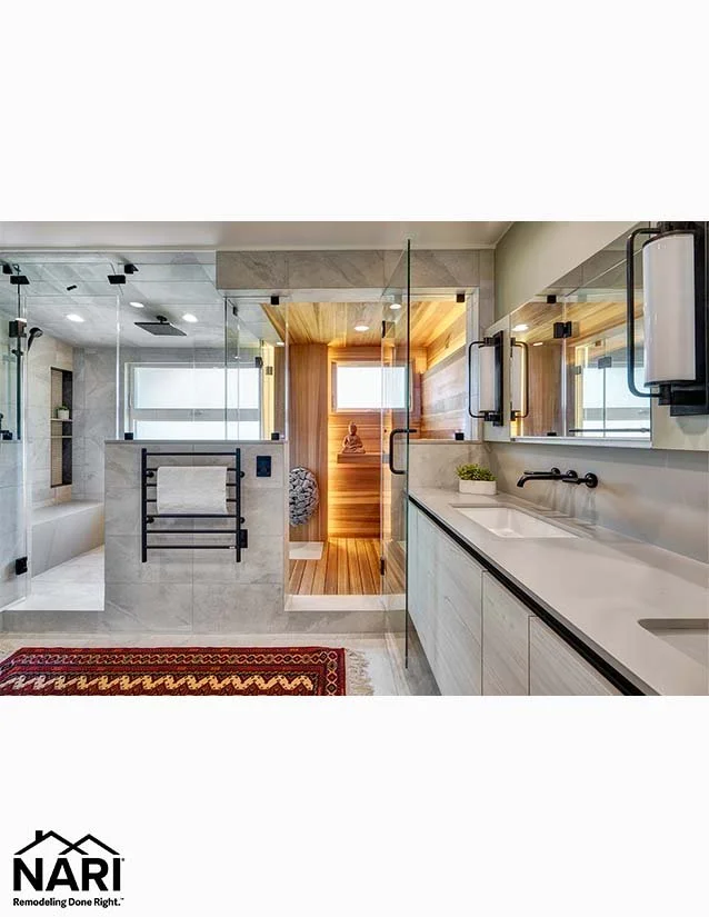 Modern bathroom with a large vanity, a walk-in shower, and a sauna in the background.