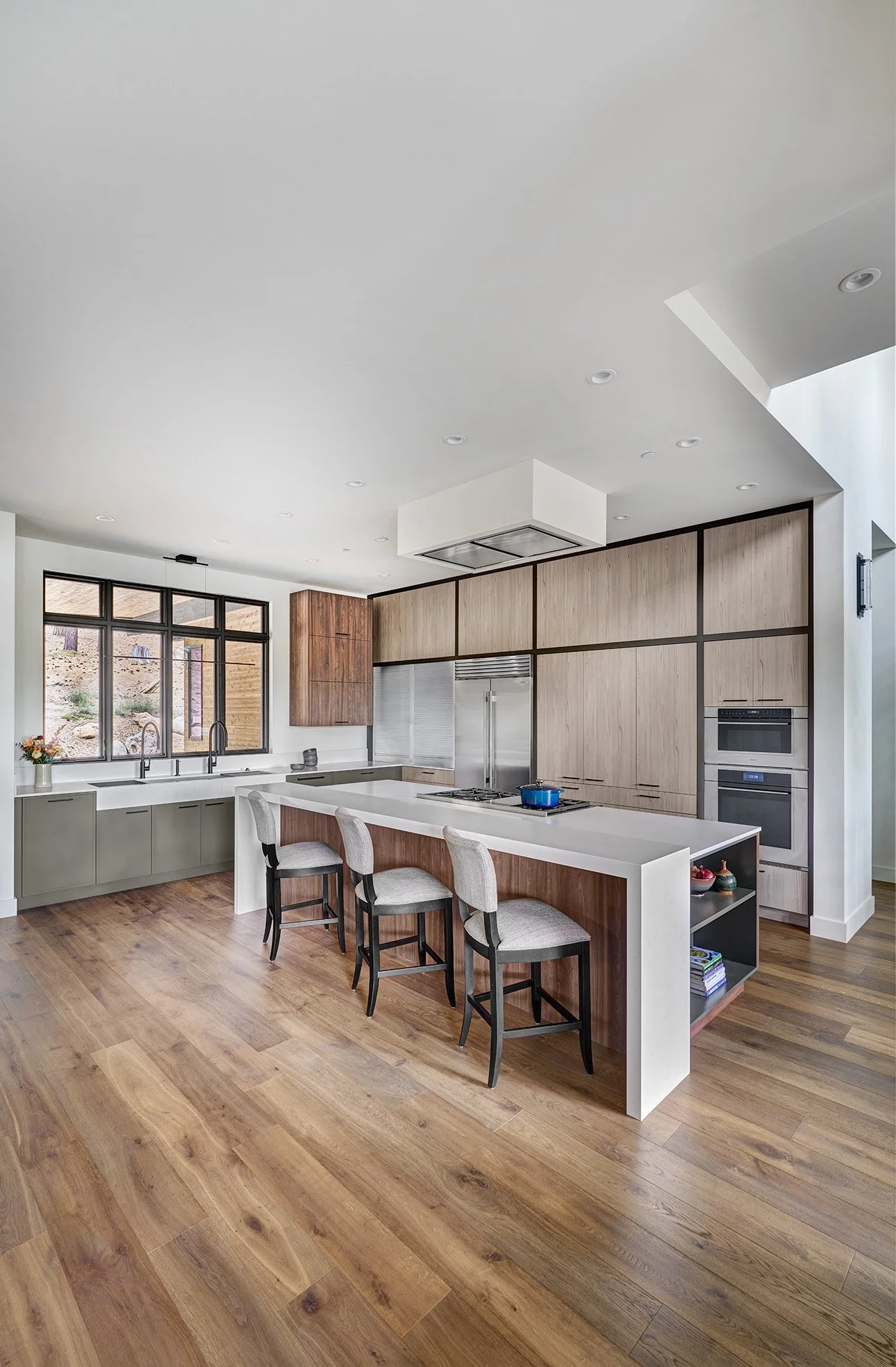 Mountain modern kitchen interior design, warm wood laminate cabinetry, earthy green cabinetry accents, large seating island, The Galley Workstation sink