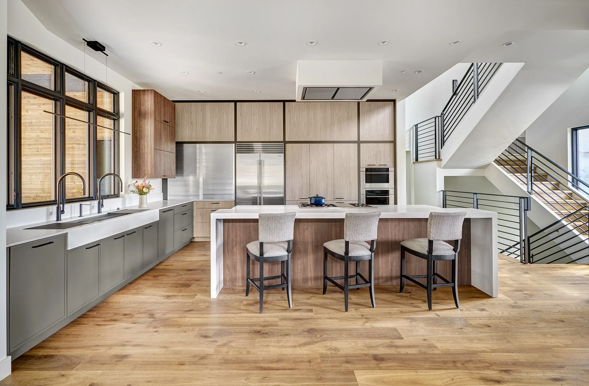 Mountain modern kitchen interior design, warm wood laminate cabinetry, earthy green cabinetry accents, large seating island, The Galley Workstation sink