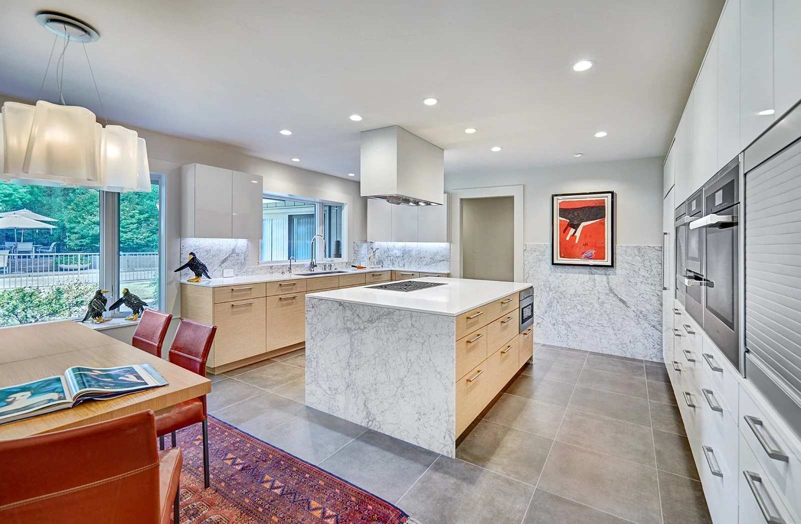 Modern kitchen remodel, wood wrapped white tall cabinet wall, appliance garage, stone waterfall island, workstation sink