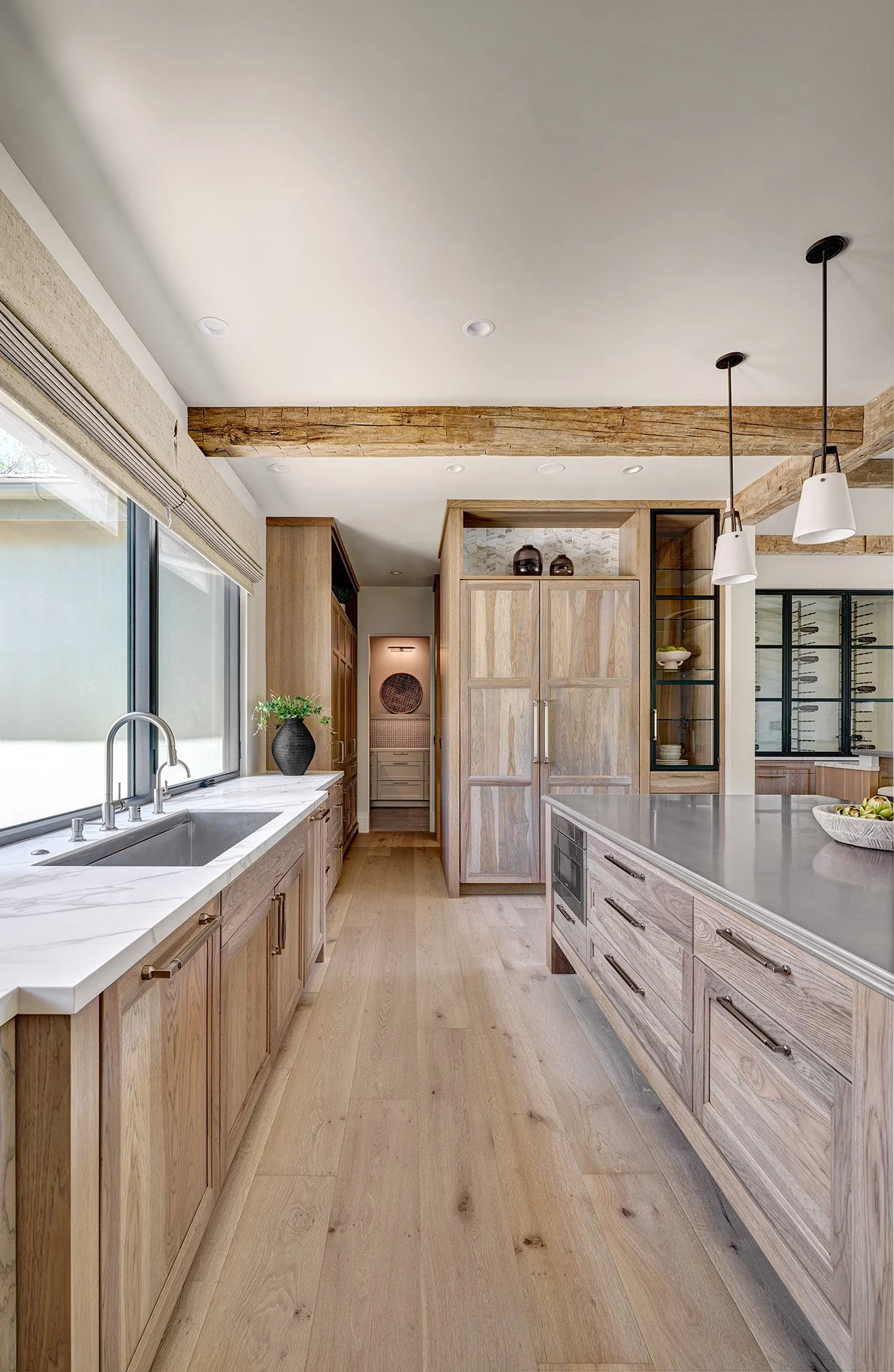 French Villa style hickory cabinetry, large metal finish island top, rustic beams, glass front cabinetry, Galley Workstation, Wolf Range