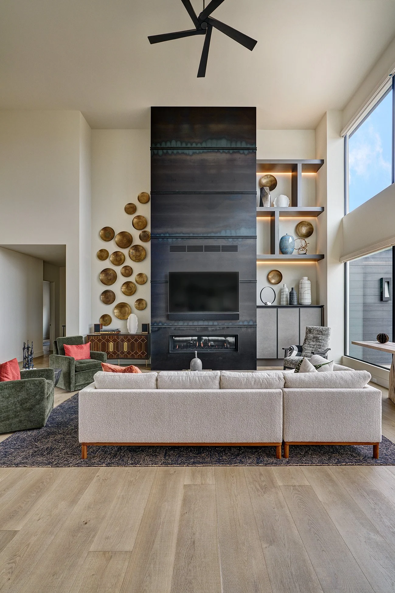 Modern new construction home, hot rolled steel fireplace facade, lit cabinet display shelving