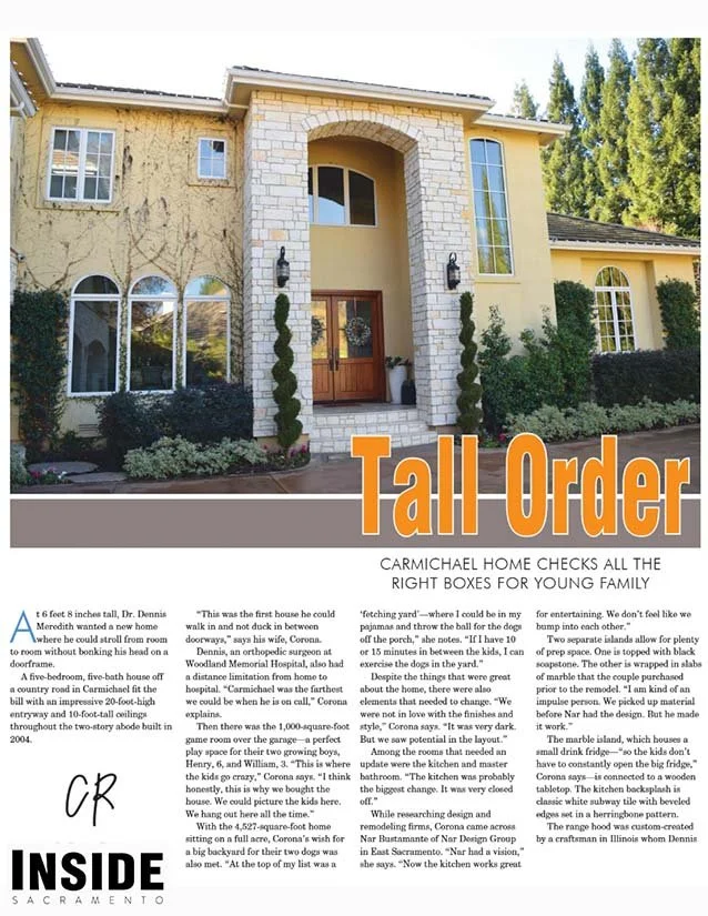Front view of a large, two-story house with a stone arch entryway, tall windows, and landscaped bushes and trees in Sacramento.
