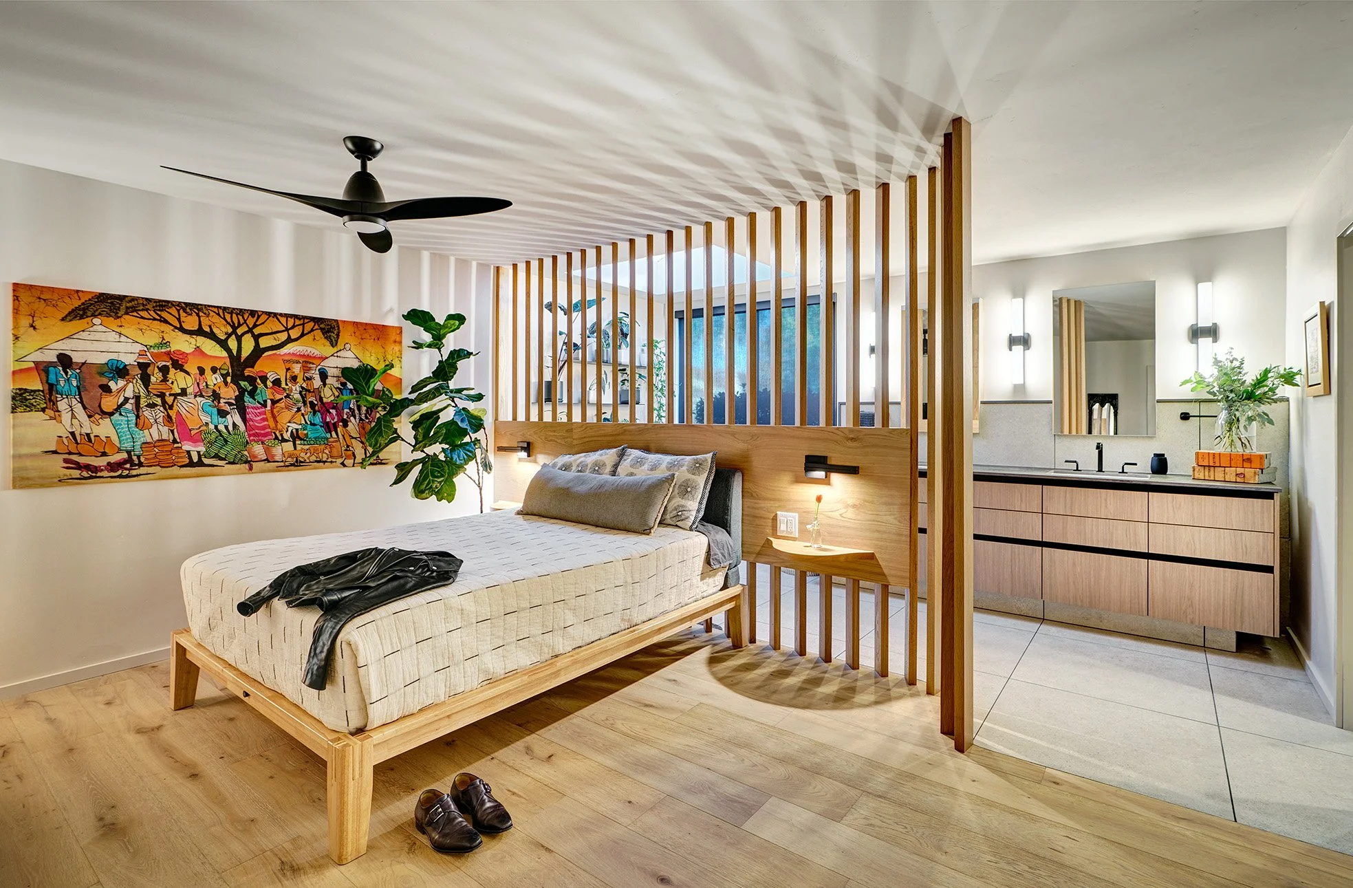 Primary bedroom remodel with slatted wall looking into primary bathroom with European laminate cabinetry