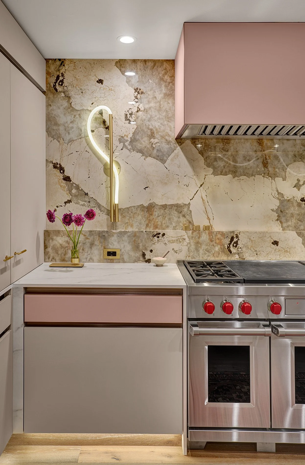 Modern kitchen remodel, blush glass drawer fronts and hood, Luke Lamp Co. sconce, European cabinetry, Wolf range