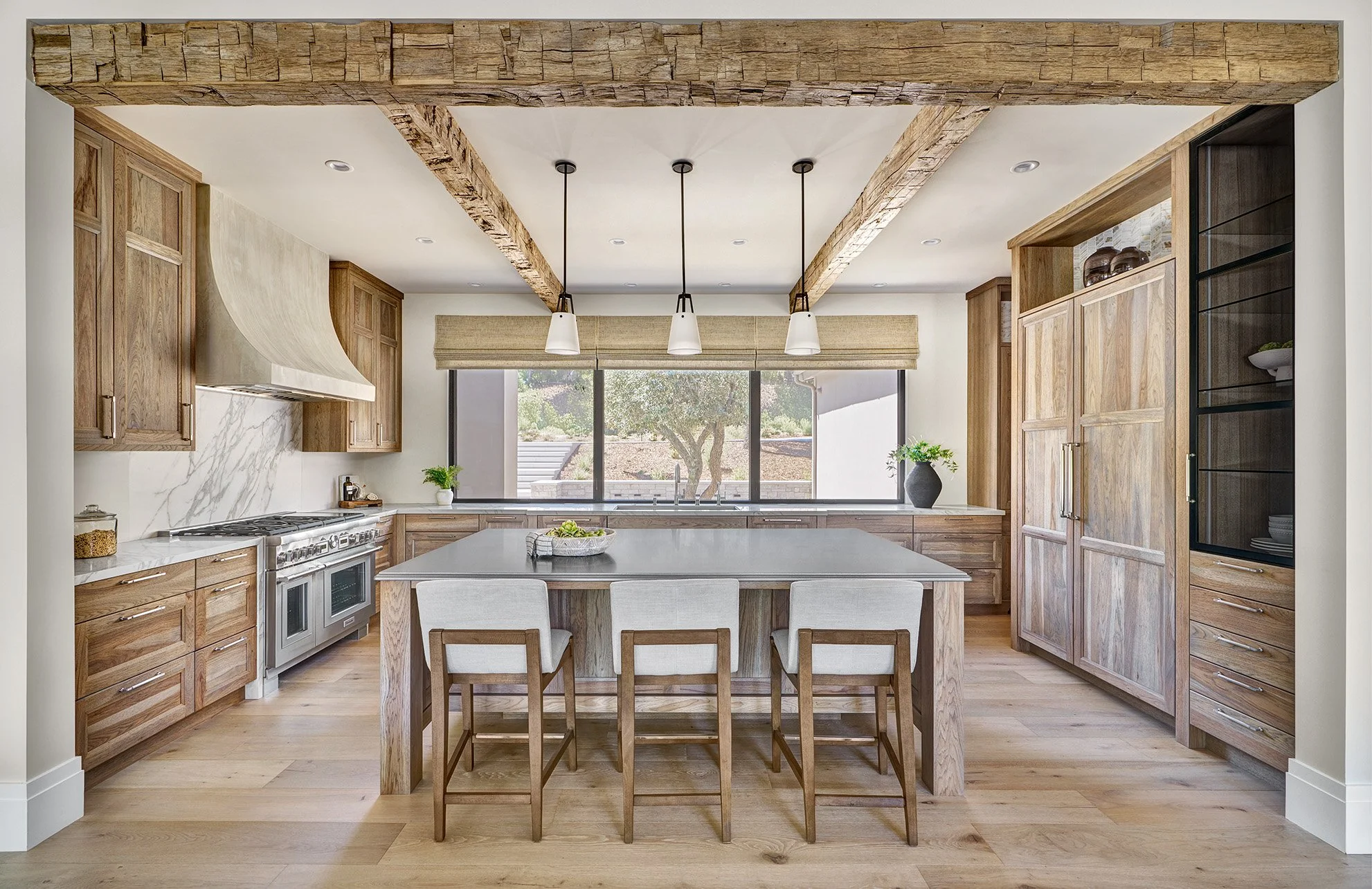 French Villa style hickory cabinetry, large metal finish island top, rustic beams, glass front cabinetry, Galley Workstation, Wolf Range