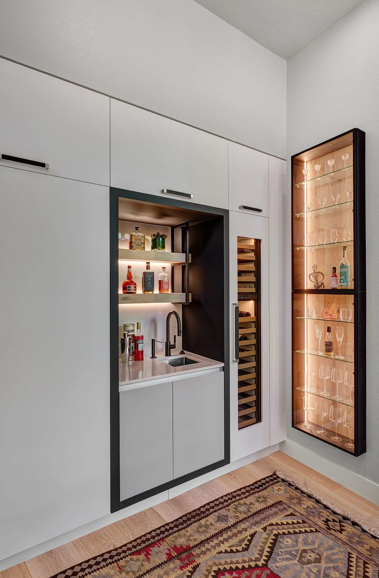 Modern kitchen remodel, black + white, large island, European cabinetry, bar, glass display cabinet